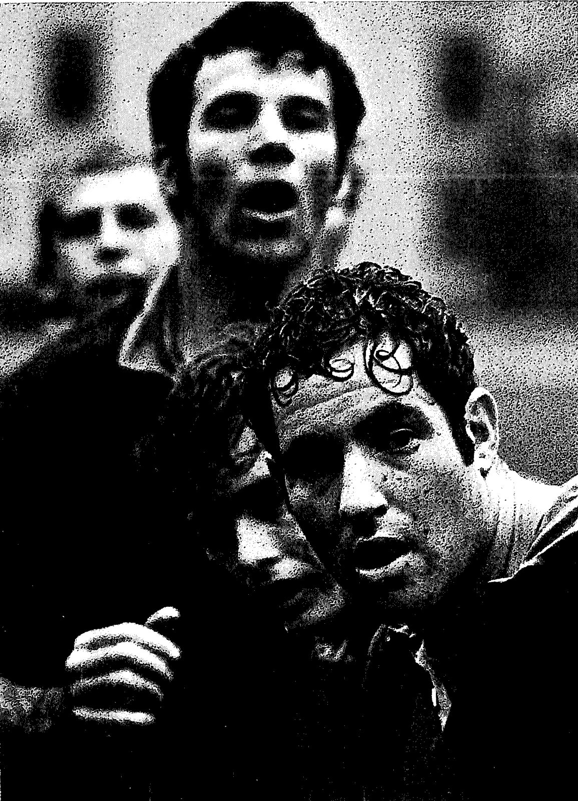 Three rain-soaked Mizzou players standing close together, the front man with wet curly hair