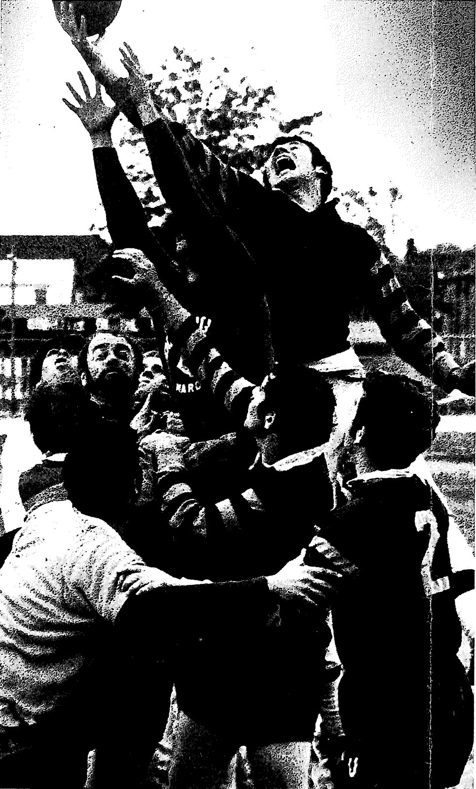 A Mizzou jumper stretching both arms high for the ball at a line out as players crowd beneath him