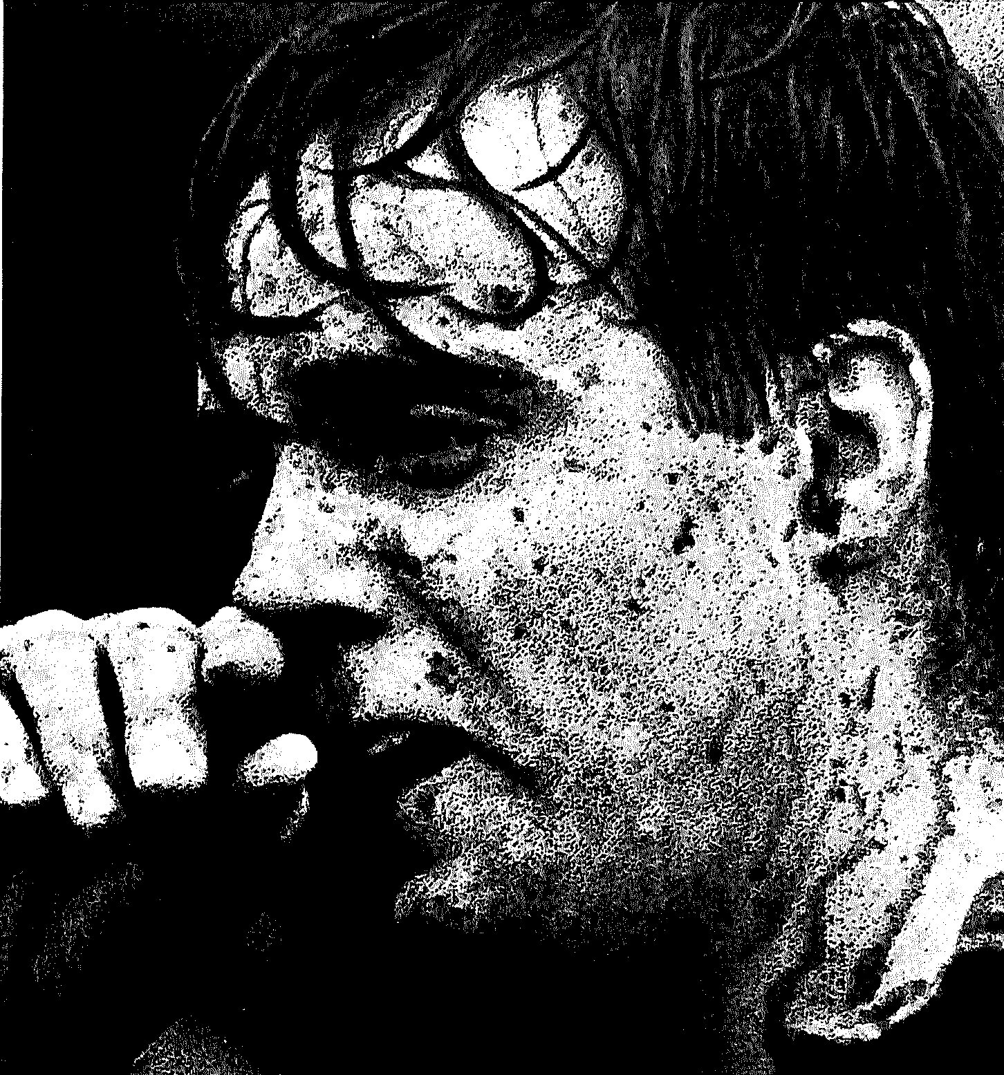 Close-up of Tom Mohan, his face and hair spattered with mud, hand raised to his mouth