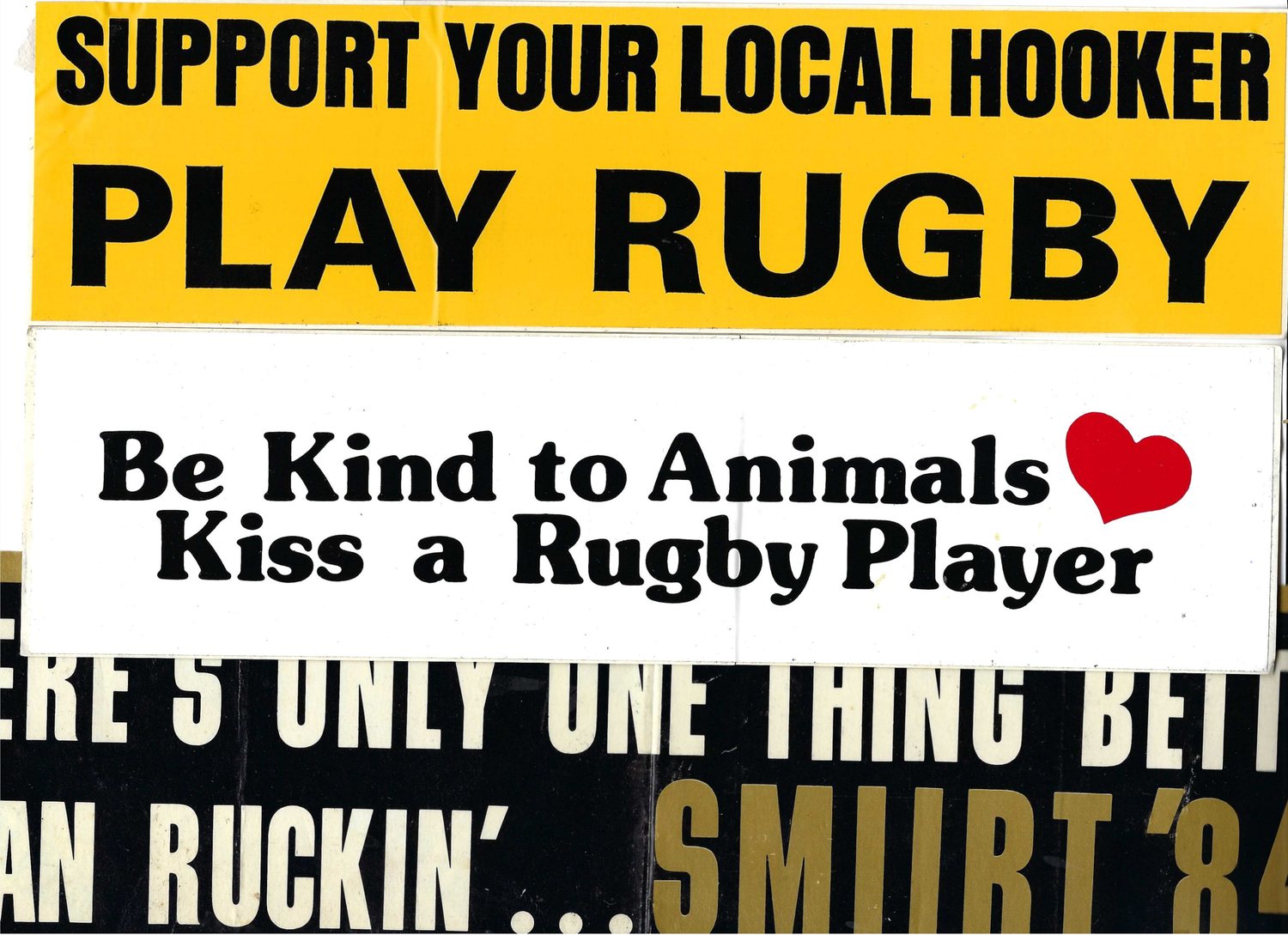 Rugby bumper stickers: Support your local hooker play rugby, Be kind to animals kiss a rugby player, and a partly hidden black and gold sticker reading SMUURT 84