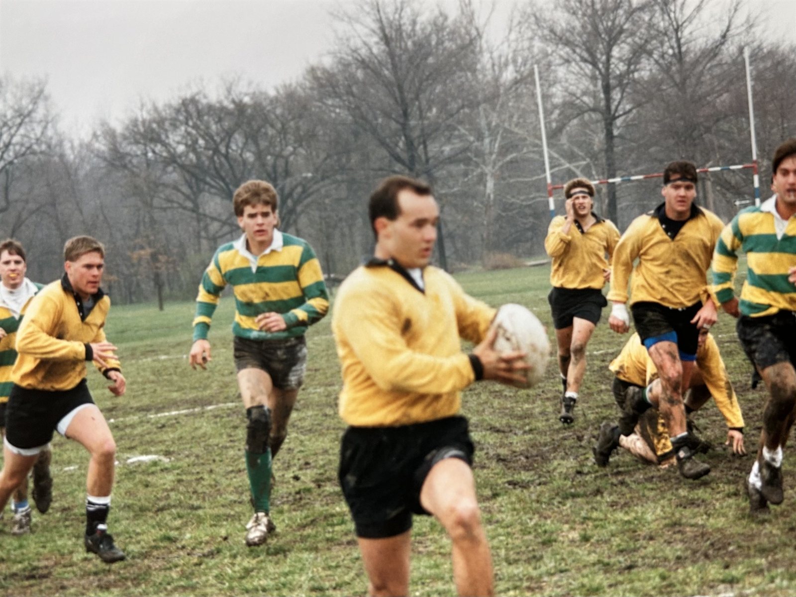 A Mizzou back in a gold jersey runs with the ball in hand as teammates and opponents chase across the field during the 1990-91 season