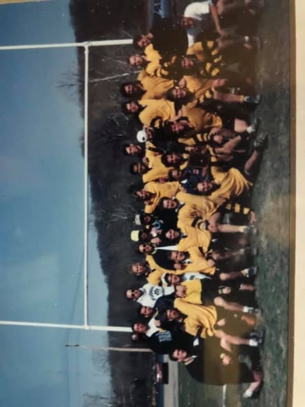 A large Mizzou squad in gold jerseys and tracksuit tops posed under the posts