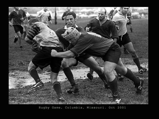 Black and white photograph of a Mizzou rugby match on a muddy Columbia pitch, captioned Rugby Game, Columbia, Missouri, October 2001