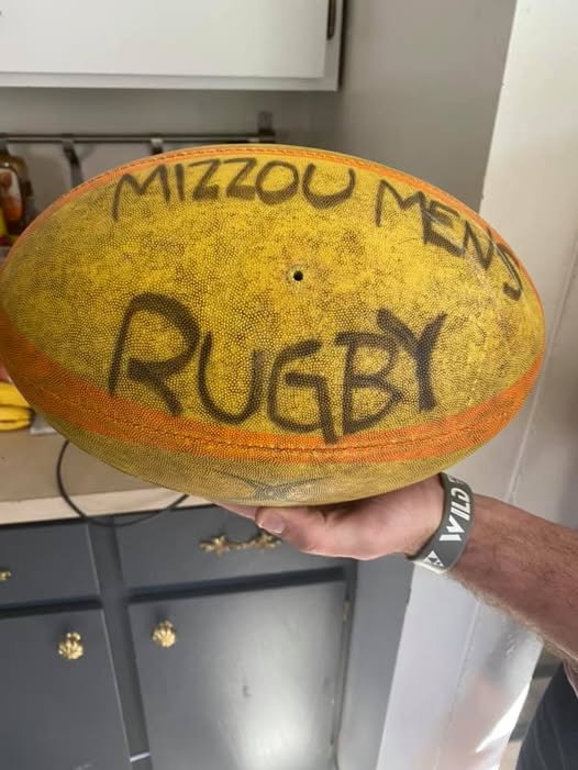 A scuffed rugby ball hand-lettered MIZZOU MENS RUGBY
