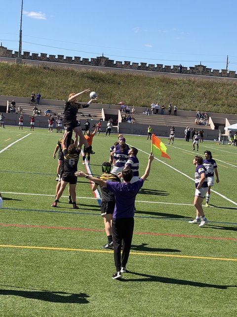 A Mizzou jumper is lifted high to take a lineout ball over the Kansas State pack, touch judge&rsquo;s flag raised