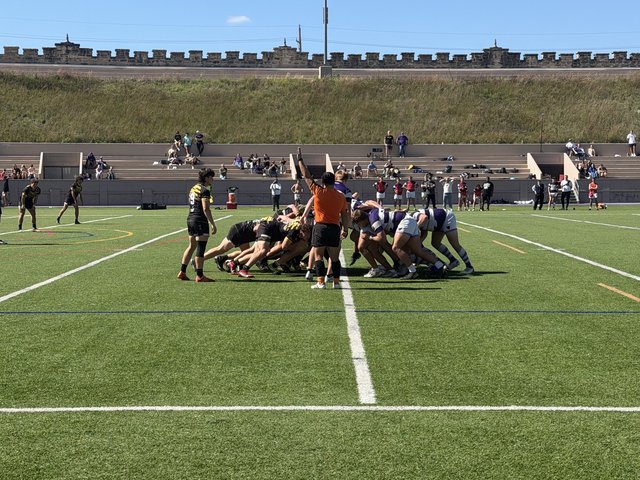 Mizzou in black and gold and Kansas State in purple and white hoops pack down for a scrum as the referee signals, the stadium&rsquo;s castle-style wall behind