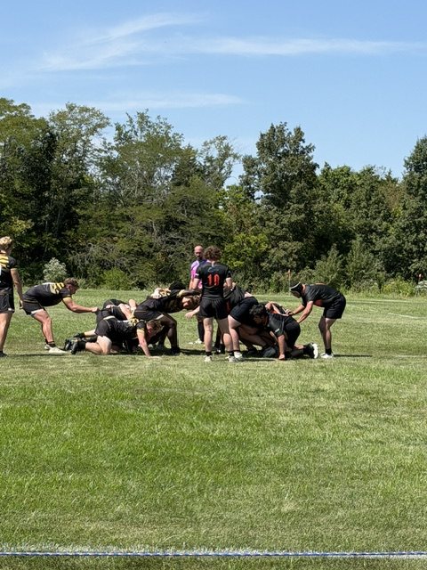 Players from both sides on the deck at a ruck near the try line