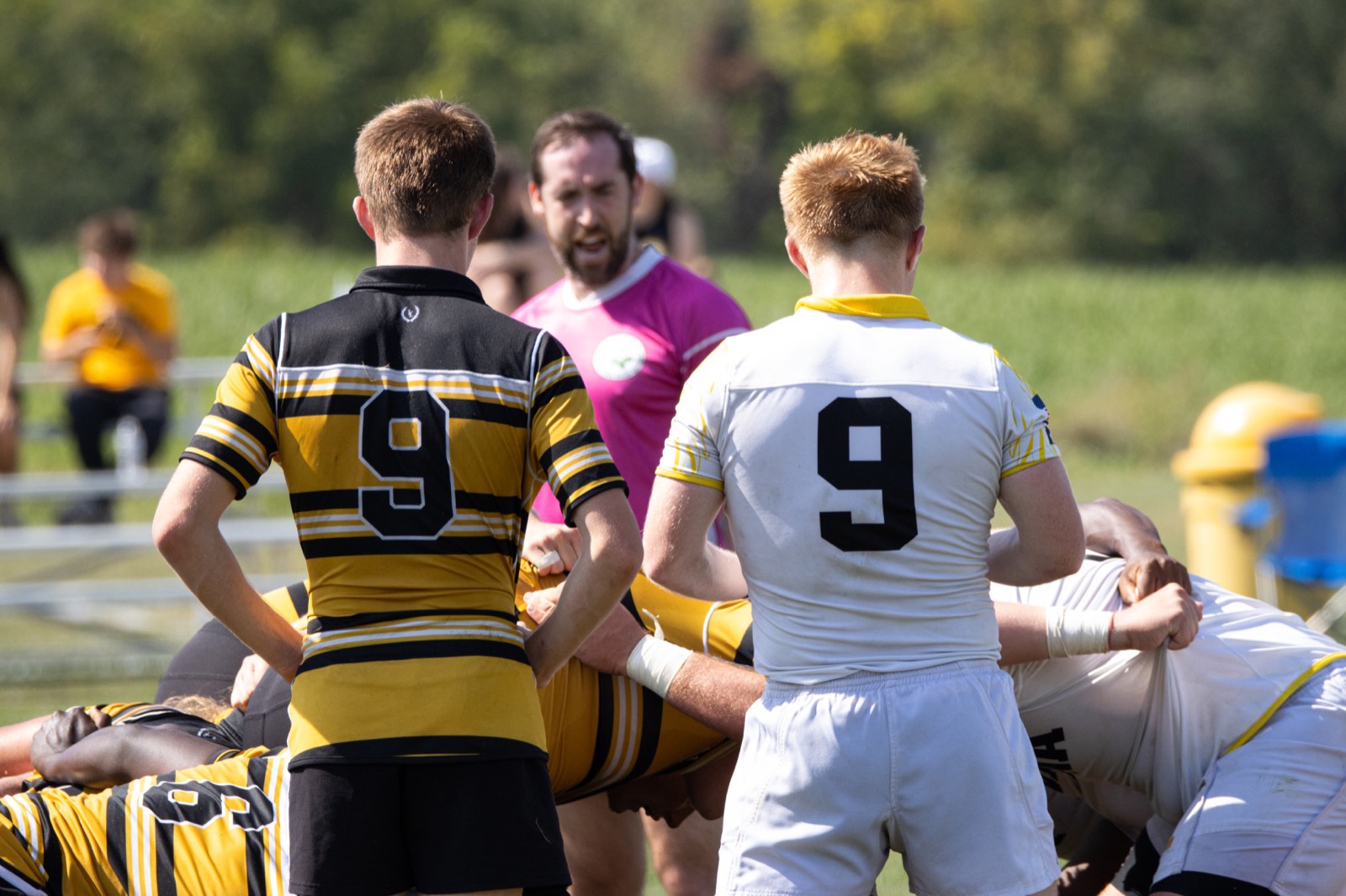 Two number nines stand over a scrum, one in Mizzou hoops and one in white