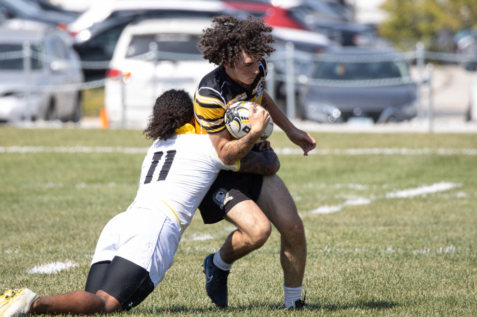 A Mizzou player brings down an Iowa ball carrier in white