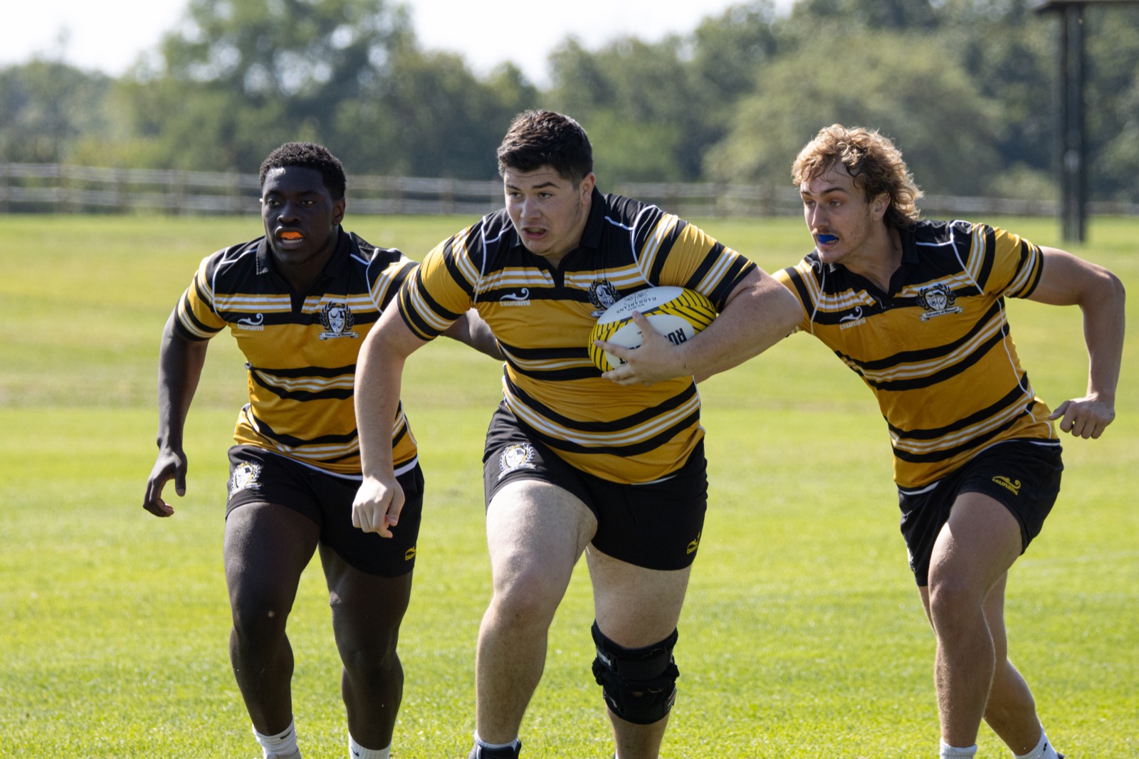 Three Mizzou forwards charge upfield together, the middle one carrying the ball
