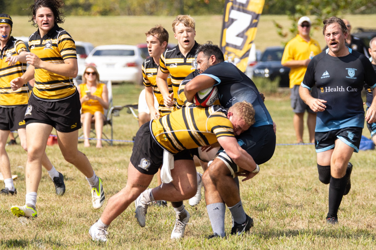 A Mizzou player is tackled by a Columbia Outlaws defender in front of spectators