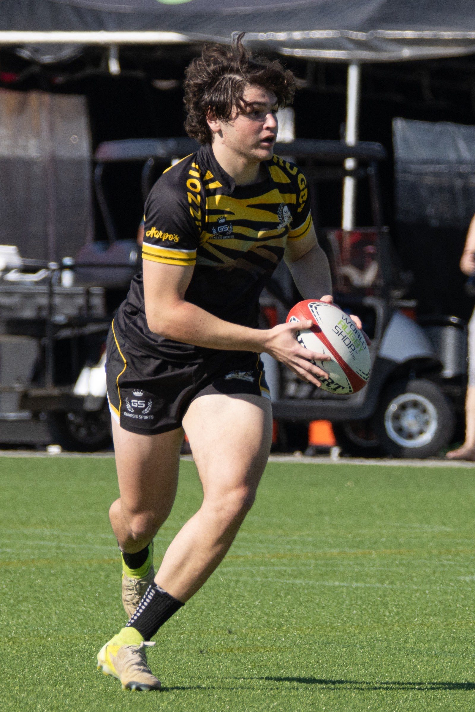 A Mizzou player carries the ball two-handed across the turf