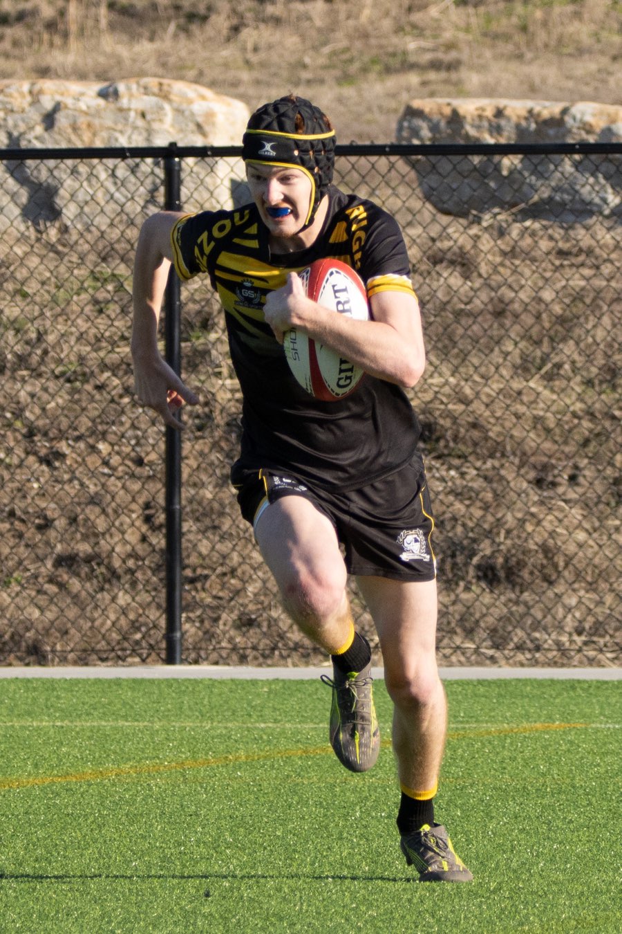 A Mizzou player sprints upfield with the ball tucked under one arm