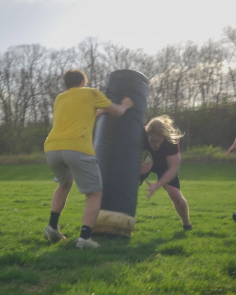 Two Mizzou players work a tackle bag drill on the practice pitch during spring 2025 training