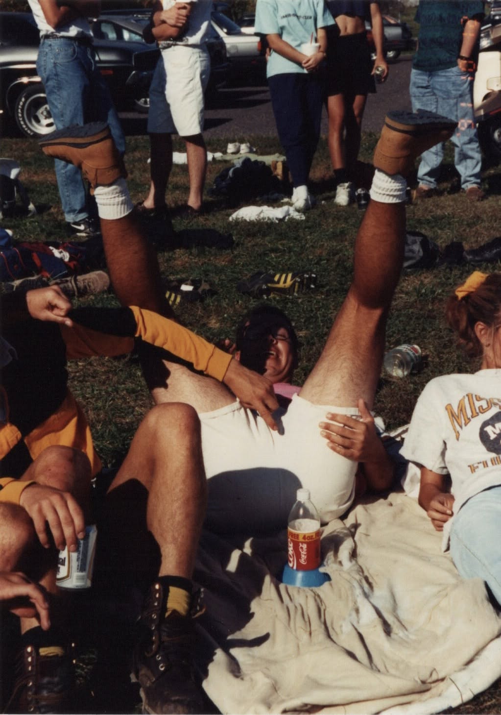 A low-angle photograph of players sitting on the ground with drinks after a match