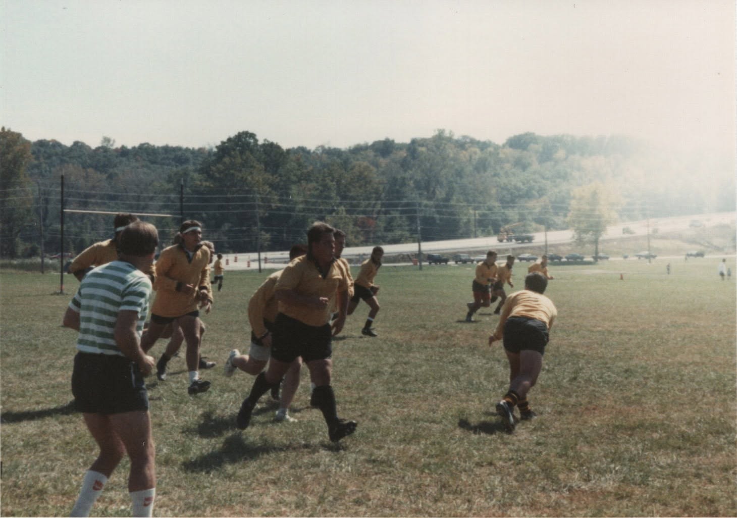 Players chase across the pitch in hazy sunshine
