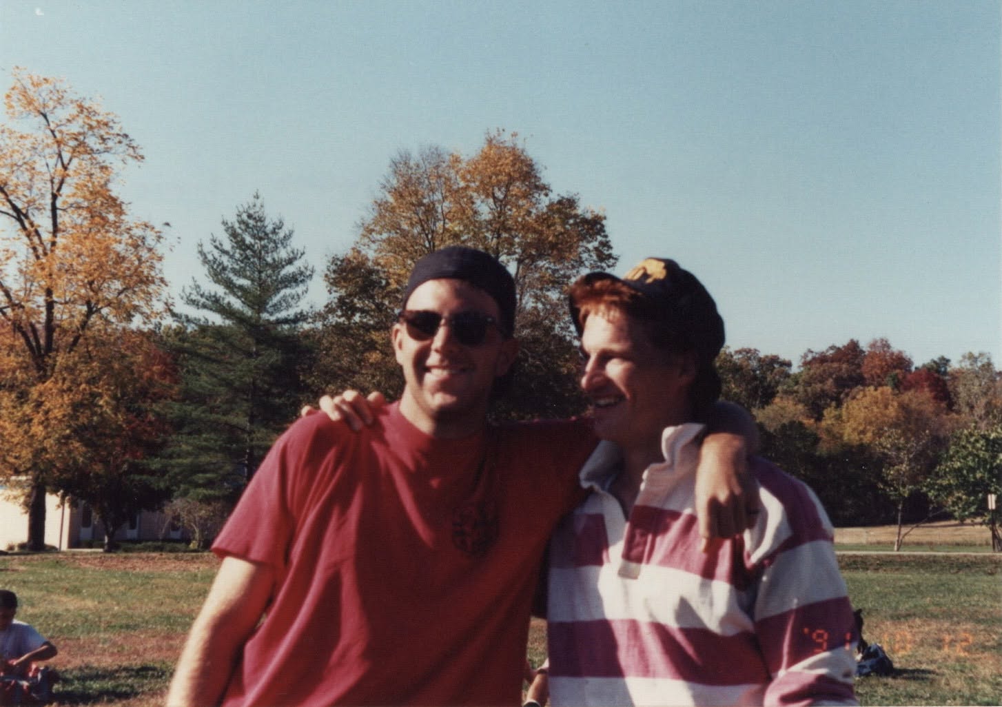 Chris Justice with a teammate in front of autumn trees