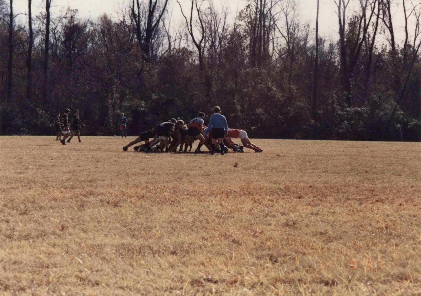 A maul seen from the far touchline on a wide open pitch