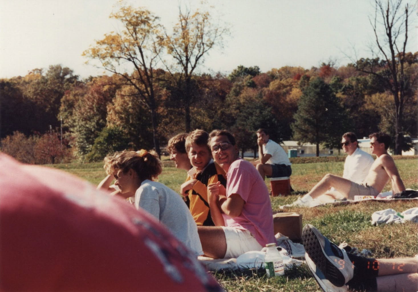 Rob Rasnic and Rob Hoens sitting on the grass bank watching another match