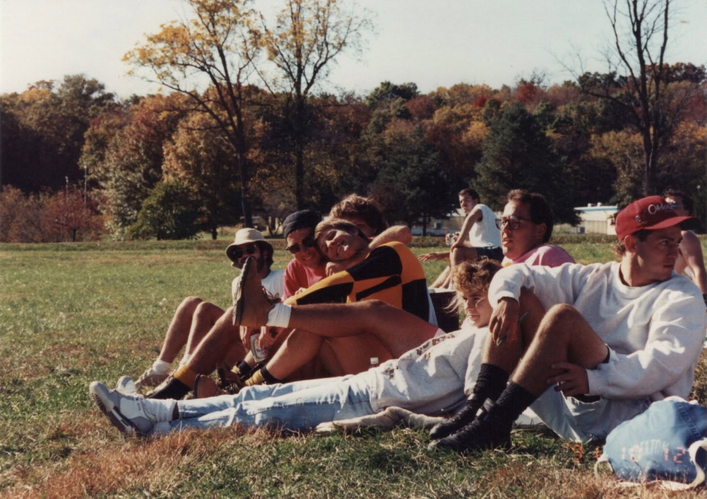 Players and friends lie on the grass beside the pitch between matches